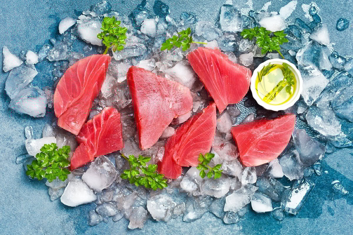 Fresh raw tuna fillet steak with spices on ice